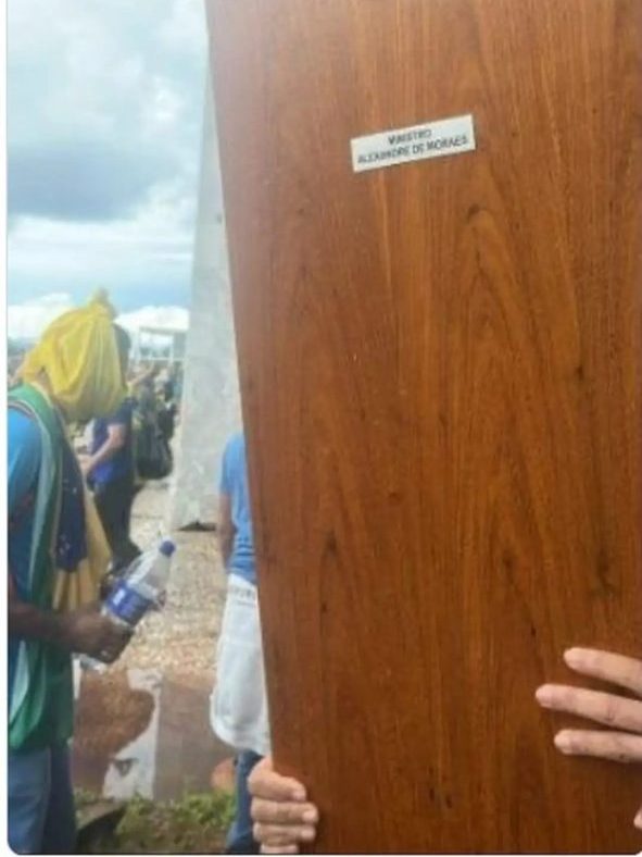 Foto divulgada nas redes sociais mostra a porta sendo carregada por vândalos Foto: Reprodução/Redes sociais